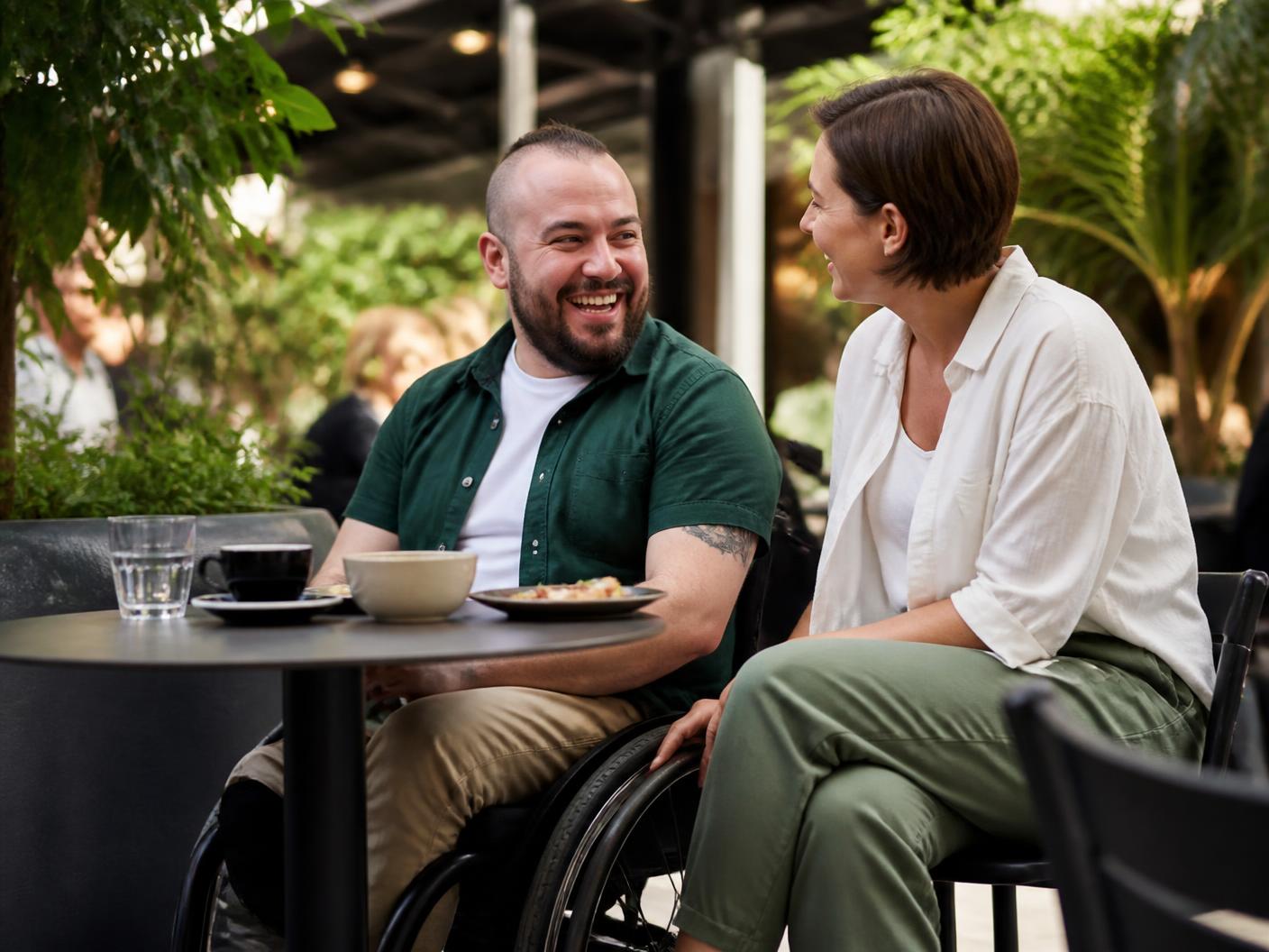 A participant and support worker sharing a relaxed community outing